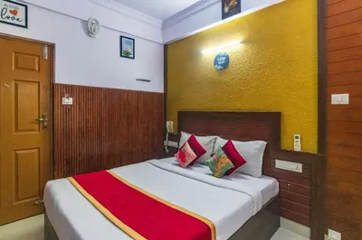 a hotel room with a bed with red and white pillows at Blue Bell Hotel in Nedumbassery
