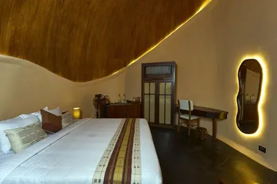 a bedroom with a bed and a desk and a mirror at Toroland Munnar in Viripara
