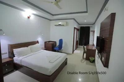 a hotel room with a bed and a television at Hotel Chithrapuri in Parli