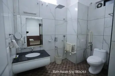 a bathroom with a toilet and a sink and a mirror at Hotel Chithrapuri in Parli