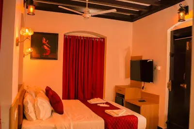 a bedroom with a bed and a red curtain at Hotel Chithrapuri in Parli