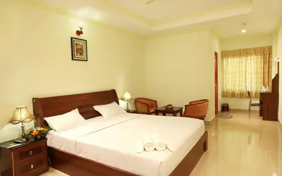 a bedroom with a bed with two towels on it at Hotel Chithrapuri in Parli