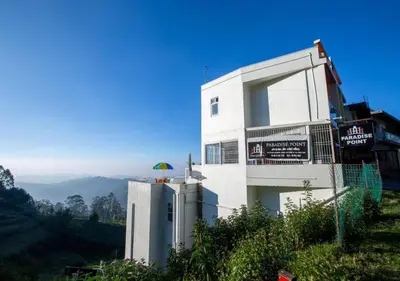 a white building on the side of a hill at Paradise Point Ooty in Ooty