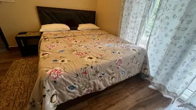 a bedroom with a bed with a floral bedspread at Lotus Exotica Homestay in Suntikoppa