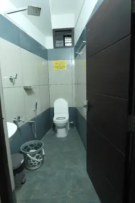 a bathroom with a toilet and a sink at Enroute Delight Residency in Kotamangalam