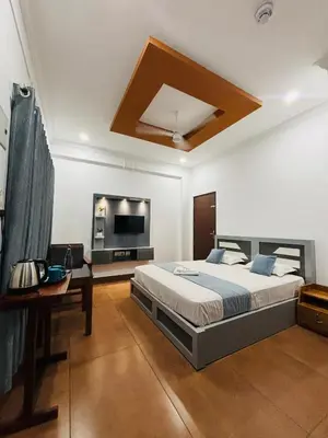 a large bedroom with a bed and a tv at Enroute Delight Residency in Kotamangalam