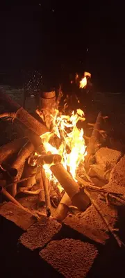 a fire pit with a chair sitting next to it at wild grove resorts in Varagampadi