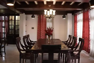 a dining room with a wooden table and chairs at Palamattam Villa Homestay,Angamaly, Kochi, Airport in Cochin