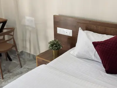a bedroom with a bed and a table with a plant at Thamarassery INN luxury and budget Rooms in Thamarassery