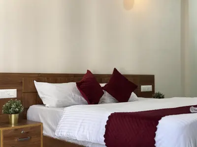 a bedroom with two beds with red and white pillows at Thamarassery INN luxury and budget Rooms in Thamarassery