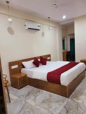 a bedroom with a large bed with red pillows at Thamarassery INN luxury and budget Rooms in Thamarassery