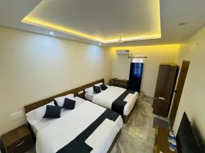 a hotel room with two beds and a window at Thamarassery INN luxury and budget Rooms in Thamarassery