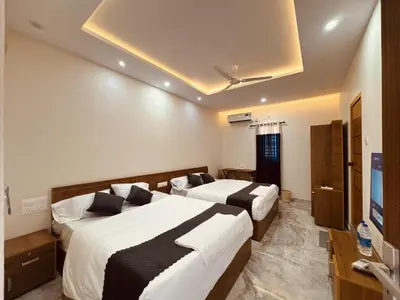 a hotel room with two beds and a television at Thamarassery INN luxury and budget Rooms in Thamarassery