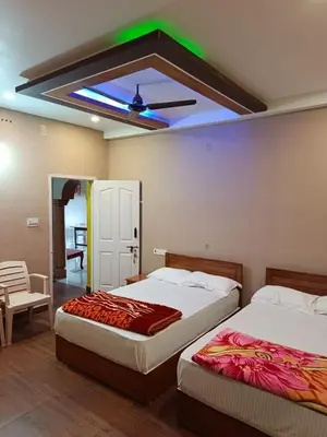 a bedroom with two beds and a ceiling with a green light at River View Homestsy in Vālpārai