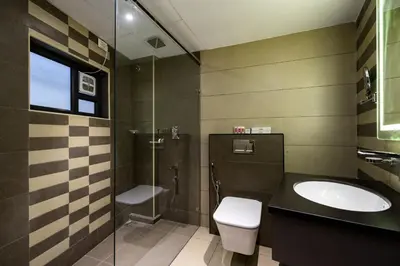 a bathroom with a toilet and a sink and a shower at Nexstay Time Square in Kozhikode