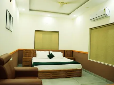 a bedroom with a bed and a chair in it at Aqualuxe Premium Suites in Vythiri