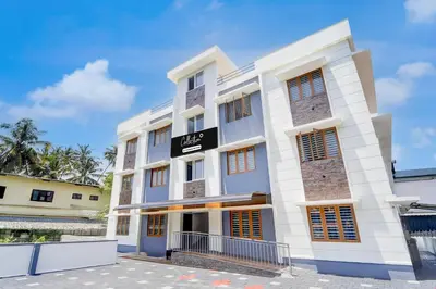 a white building with a black sign on it at Super Collection O Westhill Near Govt Engg College in Calicut
