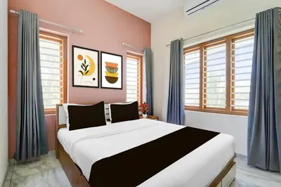 a bedroom with a large bed and windows at Super Collection O Westhill Near Govt Engg College in Calicut