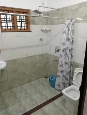 a bathroom with a shower and a toilet at Naduthotty Holiday Home in Viripara