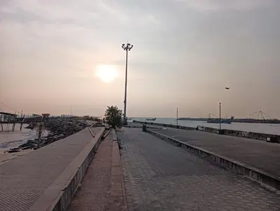 a street light on a sidewalk next to the water at Captain's Castle in Pallipuram