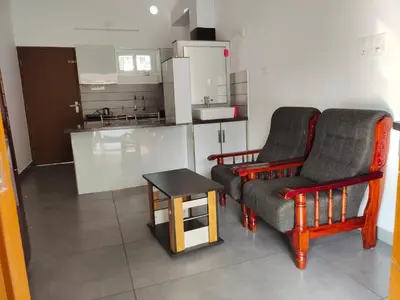 a living room with two chairs and a table at Captain's Castle in Pallipuram
