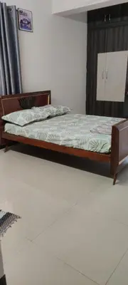 a bed with a wooden frame in a room at Regi's Adobe - Entire Place -Service Apartment for Rent in Coimbatore