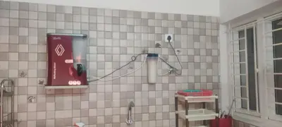 a tiled bathroom with a phone on the wall at Regi's Adobe - Entire Place -Service Apartment for Rent in Coimbatore