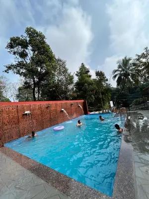 a group of people in a swimming pool with a frisbee at Blizzard Pool Villa in Padinjarathara