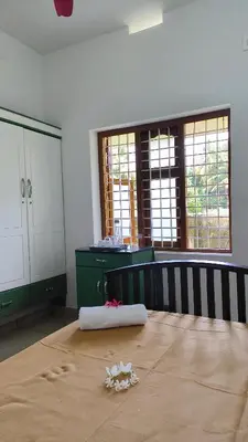 a room with a table with flowers on it at Ashirvad Homes in Mannārakkāt