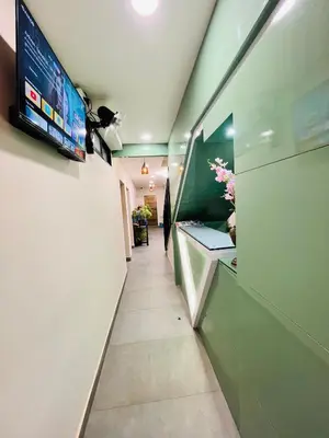 a hallway of an office with a tv on a wall at Marhaba inn in Kozhikode
