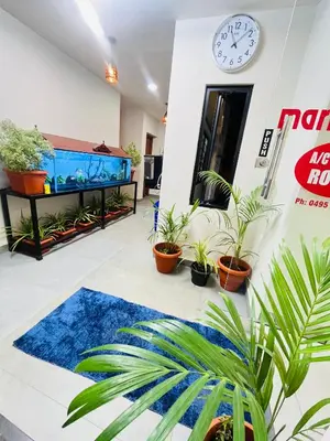 a large aquarium in a room with plants at Marhaba inn in Kozhikode