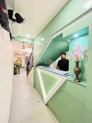 a man is sitting at a counter in a room at Marhaba inn in Kozhikode