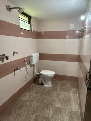 a bathroom with a toilet and a window at CozyHaven in Quilāndi