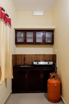 a kitchen with a stove and a sink and a window at sky blue villa in Vythiri