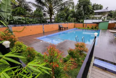 a swimming pool in the middle of a garden at sky blue villa in Vythiri