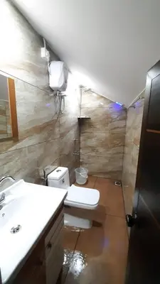a bathroom with a white toilet and a sink at Wildglamps Athirappilly in Athirappilly