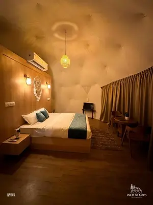 a bedroom with a bed and a table and a piano at Wildglamps Athirappilly in Athirappilly