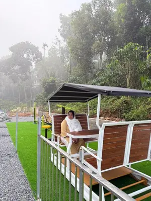 a man sitting at a table under a canopy at AJ Wayanad Suites in Kalpetta