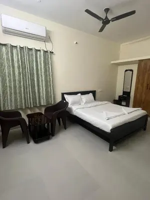 a bedroom with a bed and a ceiling fan at Subam Residency in Singānallūr