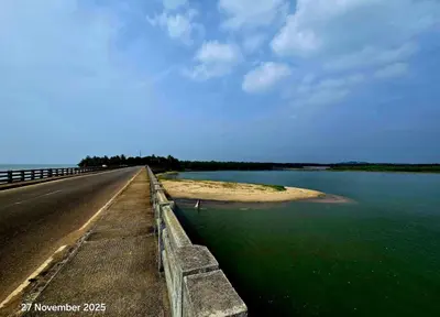 an empty road next to a body of water at Thiruthi Homestay in Vallikunnu