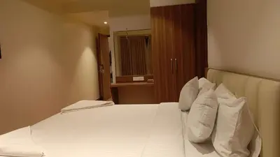 a bedroom with a bed with white pillows at Hotel Vintage Classic in Coimbatore