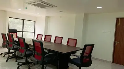 a conference room with a table and red chairs at Hotel Vintage Classic in Coimbatore