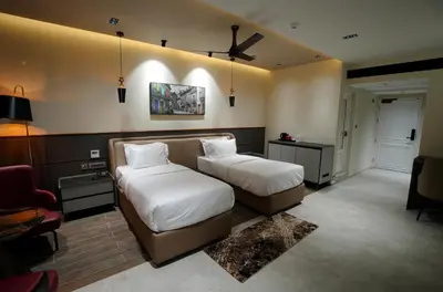a hotel room with two beds and a couch at Doro Royal Suite in Mannārakkāt
