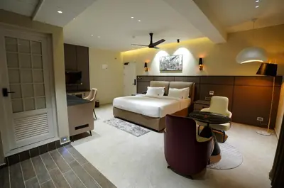 a hotel room with a bed and a desk and a computer at Doro Royal Suite in Mannārakkāt