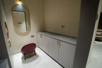 a bathroom with a mirror and a pink chair at Doro Royal Suite in Mannārakkāt