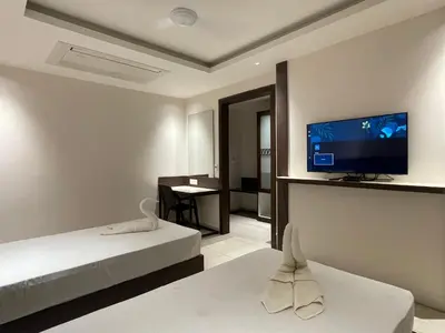 a hotel room with a bed and a flat screen tv at SV Grand in Mettuppālaiyam