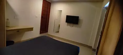 a small room with a bed and a television on the wall at Hotel Eastern in Sultan Bathery