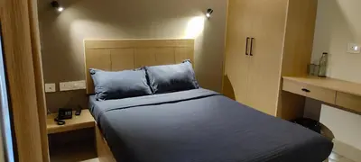 a small bedroom with a bed with blue pillows at Hotel Eastern in Sultan Bathery