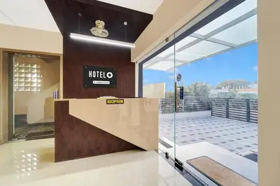 a lobby with a hotel sign on the wall at Super Hotel O Vilankurichi in Coimbatore