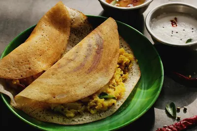 a green plate of food with two pita bread and dip at Super Hotel O Vilankurichi in Coimbatore
